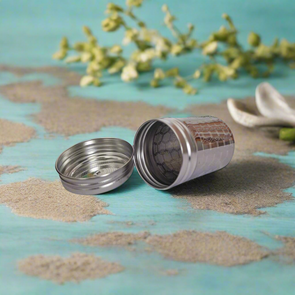 Metal tea canister with mesh filter on a white background
