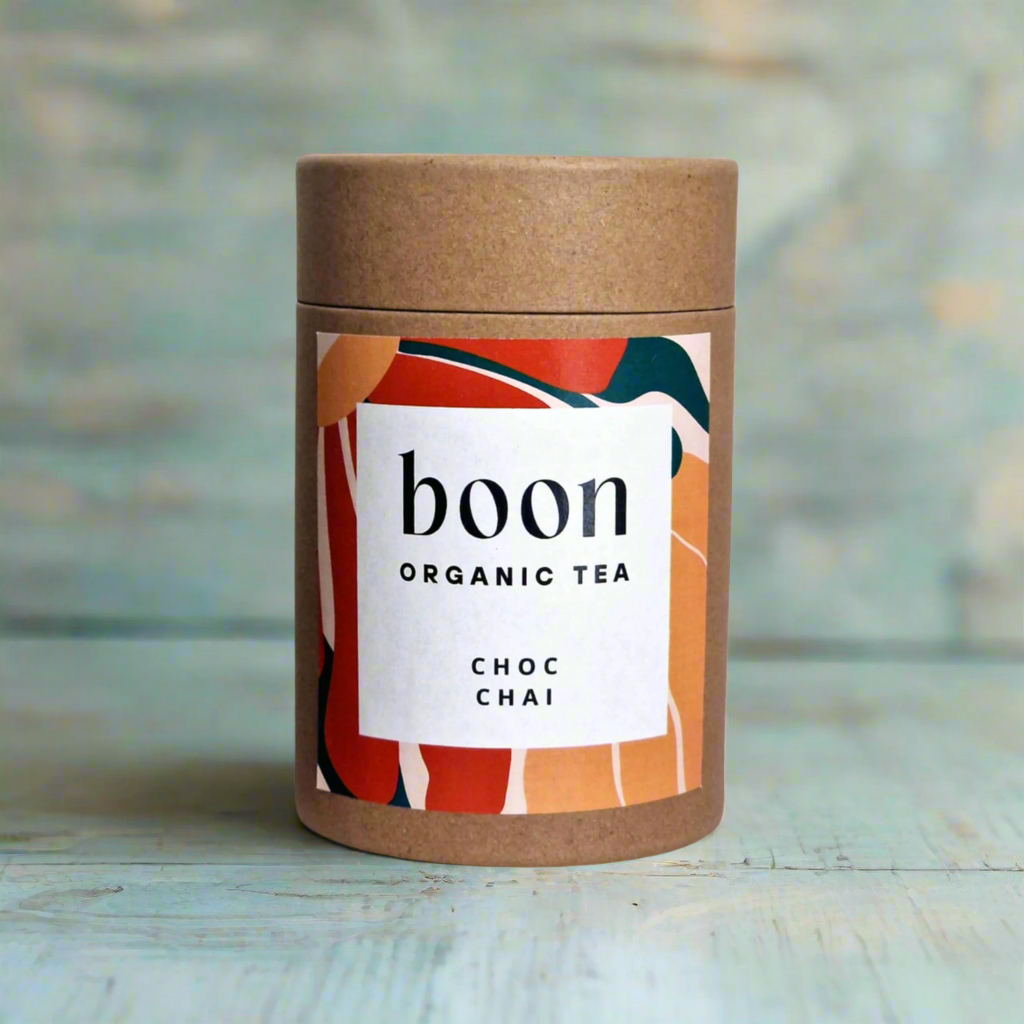 Boon Organic Tea Choc Chai container on a wooden surface with a blurred background