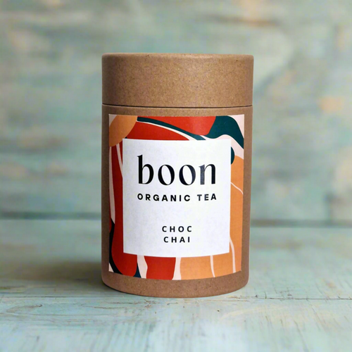 Boon Organic Tea Choc Chai container on a wooden surface with a blurred background
